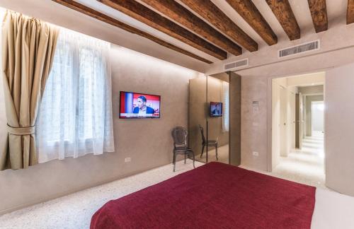 a bedroom with a bed and a tv on the wall at Rialto Luxury Flat in Venice
