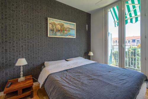 une chambre avec un grand lit et une fenêtre dans l'établissement Centre, deux pièces, calme, terrasse plein sud, à Nice