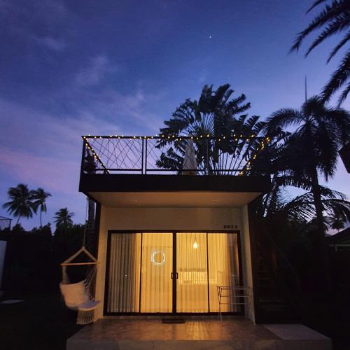 a small house with a balcony on top of it at Coconut Wells Phuket in Chalong 