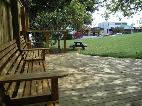 two benches sitting on a porch with a picnic table at Abelia Motor Lodge in Nelson