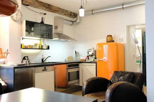 a kitchen with an orange refrigerator in a room at Klimatisiertes Loft im Herzen von Deidesheim in Deidesheim