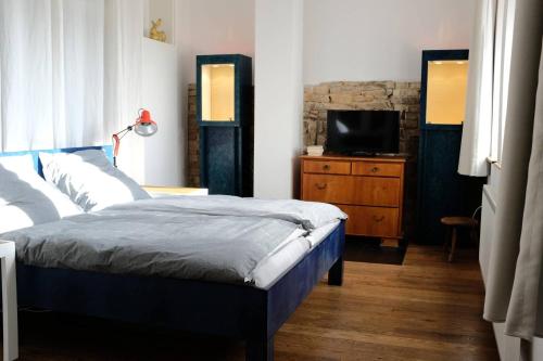 a bedroom with a bed and a tv on a dresser at Klimatisiertes Loft im Herzen von Deidesheim in Deidesheim