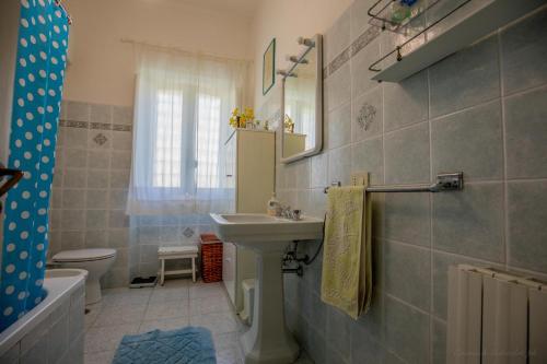 ポルト・サント・ステーファノにあるMediterranean Villaのバスルーム(洗面台、トイレ、鏡付)