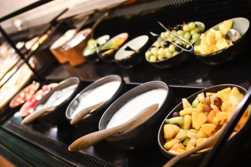 a buffet filled with bowls of fruit and spoons at Radisson Blu Hotel, Hasselt in Hasselt