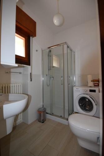 Un baño con lavabo y lavadora. en Appartamenti Massimiliano, en Peschiera del Garda