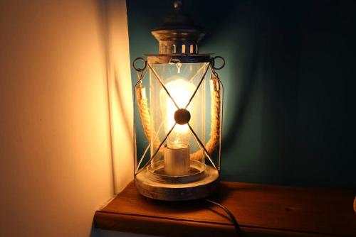 a glass lantern with a candle in it on a table at House SottoCoperta in Civitavecchia