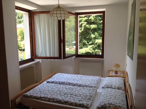 two beds in a bedroom with two windows at Casa St Uldarico in Brusino