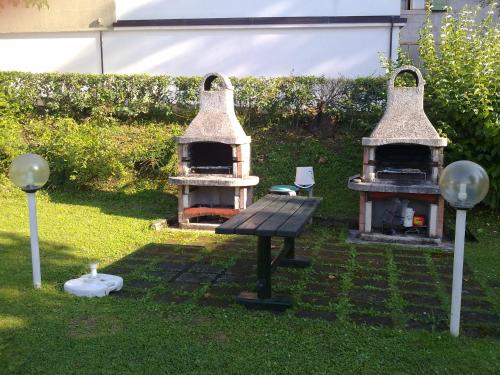 a backyard with a grill and a table in the grass at Casa St Uldarico in Brusino