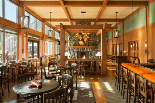 a restaurant with tables and chairs and a fireplace at Skamania Lodge in Stevenson