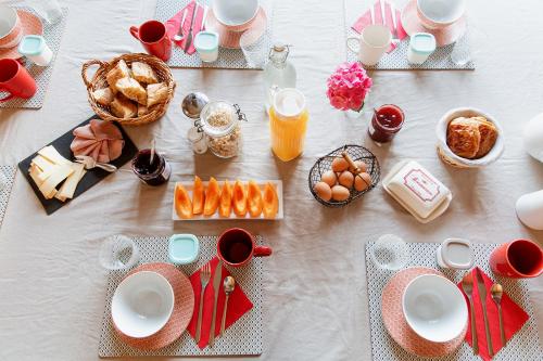 ein Tisch mit Frühstücksspeisen und Getränken darauf in der Unterkunft La Poterne l Chambres d'hôtes à Epernay in Épernay