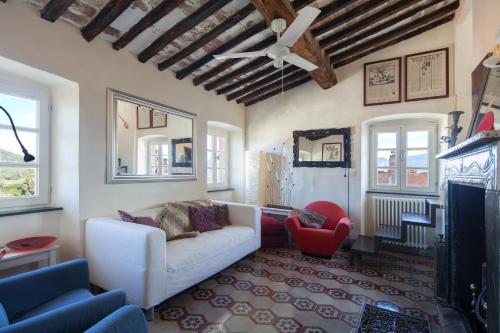 a living room with a white couch and a red chair at Fivestay Roof terrace overlooking the gulf in Monte Marcello
