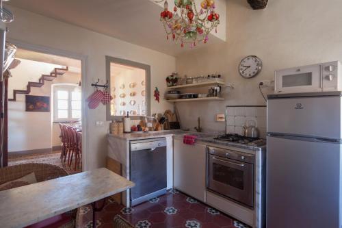a kitchen with a refrigerator and a stove top oven at Fivestay Roof terrace overlooking the gulf in Monte Marcello