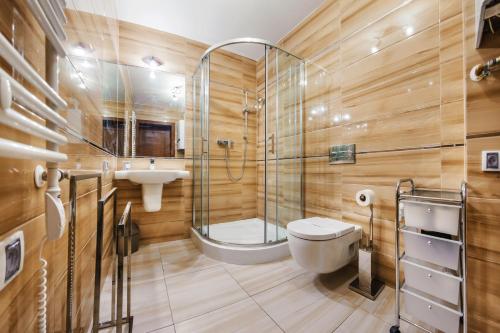 a bathroom with a shower and a toilet and a sink at Rezydencja Park, Sun & Snow in Mielno