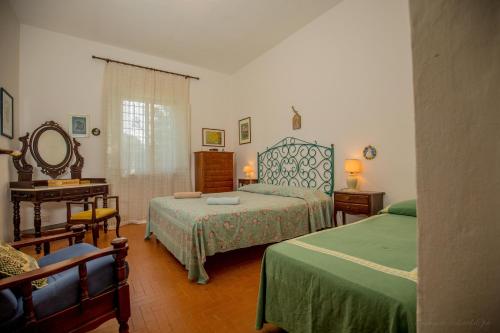 ポルト・サント・ステーファノにあるMediterranean Villaのベッドルーム1室(ベッド2台、テーブル、鏡付)