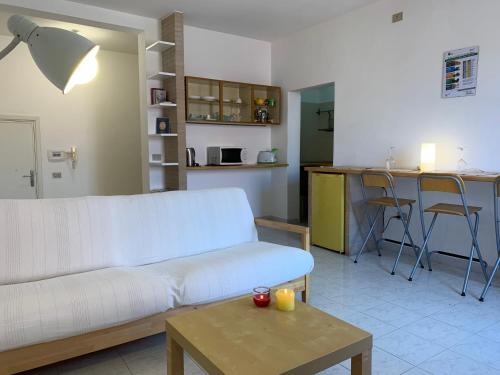 een woonkamer met een witte bank en een tafel bij Gioberti 25 in Alghero