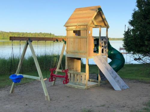 a playground with a slide and a play house at Blue Moon Resort & Motel in Hill City