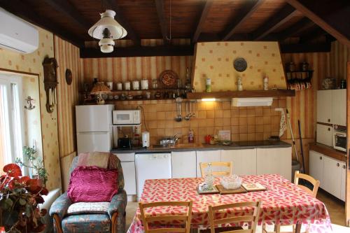 - une cuisine avec une table, une table et des chaises dans l'établissement chez Jeannette, à Marcillac-Saint-Quentin