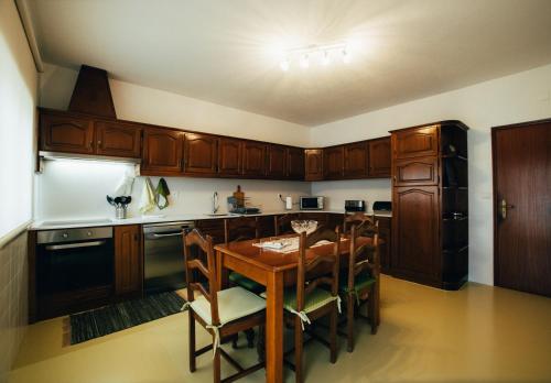 a kitchen with wooden cabinets and a wooden table at Pedras Salgadas Apartment in Pedras Salgadas