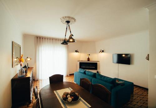 a living room with a blue couch and a table at Pedras Salgadas Apartment in Pedras Salgadas