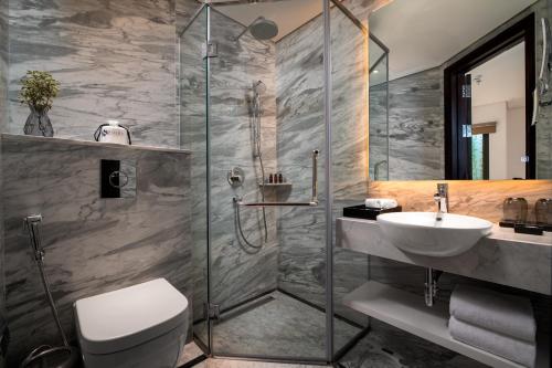 a bathroom with a shower and a toilet and a sink at Soleil Boutique Hotel Hanoi in Hanoi