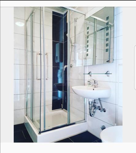 a bathroom with a glass shower and a sink at Nordseebriese in Hage