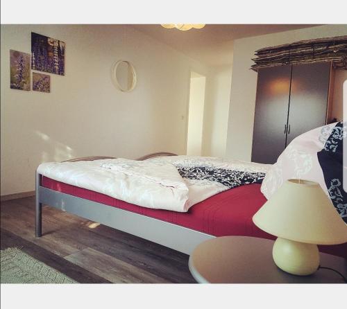 a bedroom with a bed and a table with a lamp at Nordseebriese in Hage