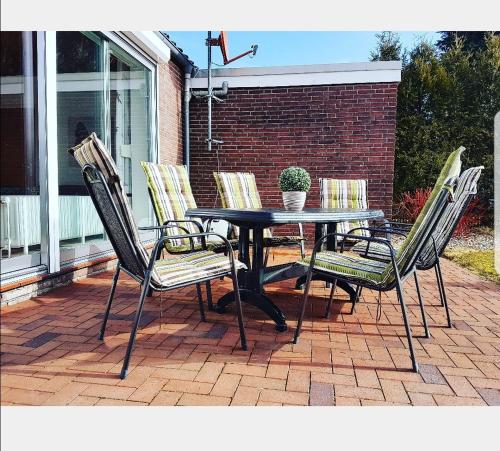 a table and four chairs on a patio at Nordseebriese in Hage