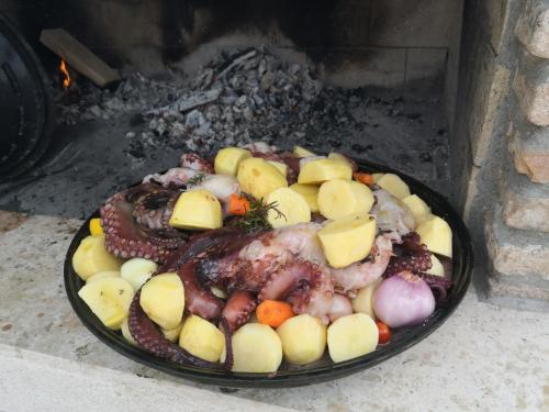 a plate of meat and vegetables cooking in an oven at Casa Romantica in Umag