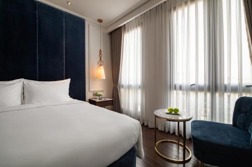 a hotel room with a bed and a chair at Soleil Boutique Hotel Hanoi in Hanoi