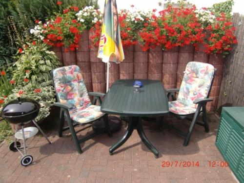 a green table and two chairs and an umbrella at Ruegen_Fewo 24 in Thesenvitz