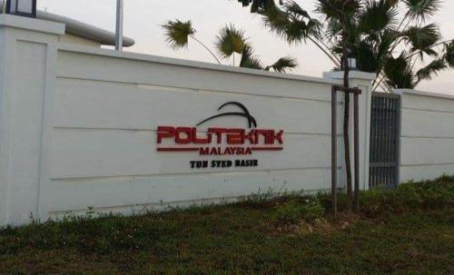 a white building with a sign on the side of it at Basrie Villa Pagoh - Mini Cinema , Karaoke , Private Pool , WiFi , NetFlix in Muar
