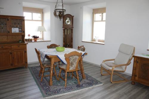 a dining room with a table and chairs and a clock at Die Seele baumeln lassen in der Alten Druckerei in Viechtach