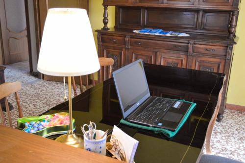 a laptop computer sitting on a desk with a lamp at Villa Luisa B&B in Candelo