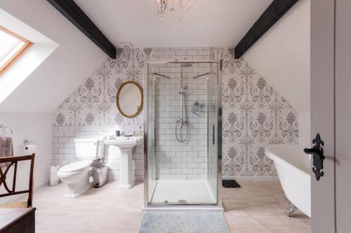 y baño con ducha, aseo y lavamanos. en The Hidden House en Stroud