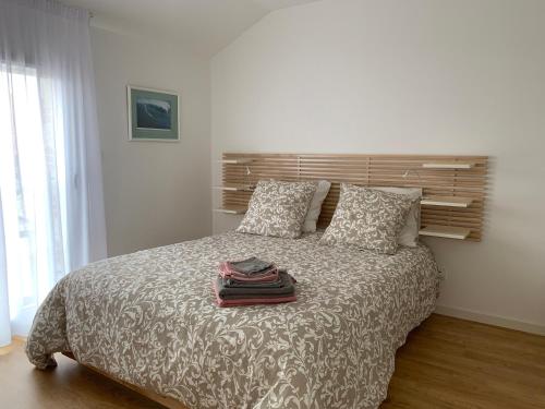 a bedroom with a bed with pillows and towels on it at LE CLOS SAINTE MARIE in Pornic