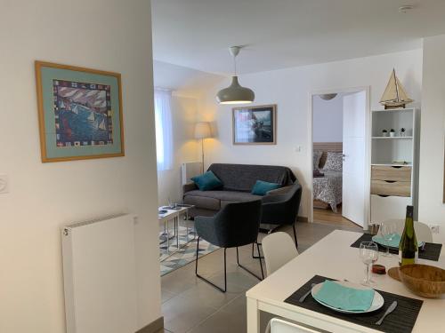 un salon avec un canapé et une table avec des chaises dans l'établissement LE CLOS SAINTE MARIE, à Pornic