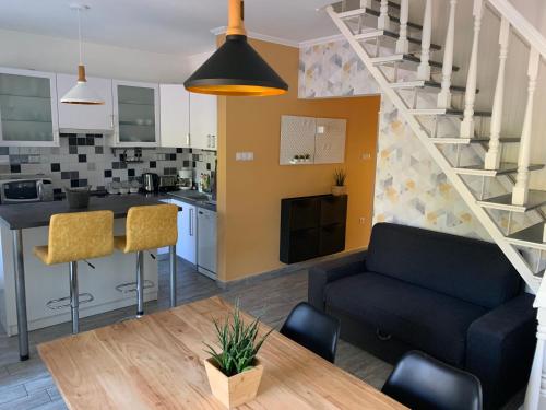 Csuka48 Apartman في سزارفاس: غرفة معيشة ومطبخ مع أريكة وطاولة