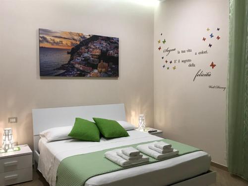 Schlafzimmer mit einem Bett mit grüner und weißer Bettwäsche in der Unterkunft Le Tre Gemme in Pompei