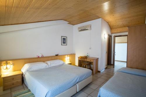 a bedroom with two beds and a wooden ceiling at Al Bottegon in Tricesimo