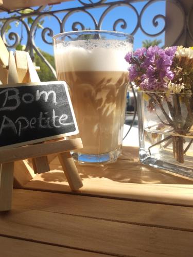 a glass of beer sitting on a table with a sign at Bea's Bed & Breakfast in Tavira