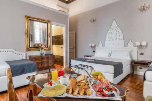 a bedroom with a bed and a tray of food on a table at I Tre Moschettieri - D'Artagnan in Rome