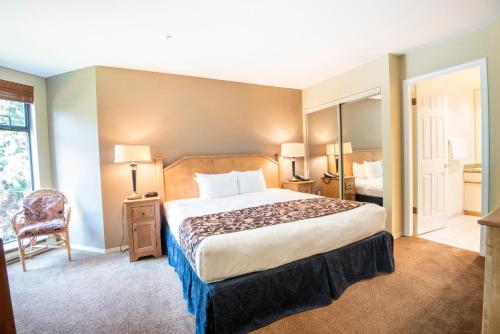 a hotel room with a large bed and a chair at The Ironwood on Blueberry Hill in Whistler