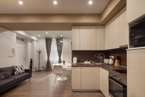 a kitchen and living room with a couch and a table at Kastely Apartments - Buda Castle in Budapest