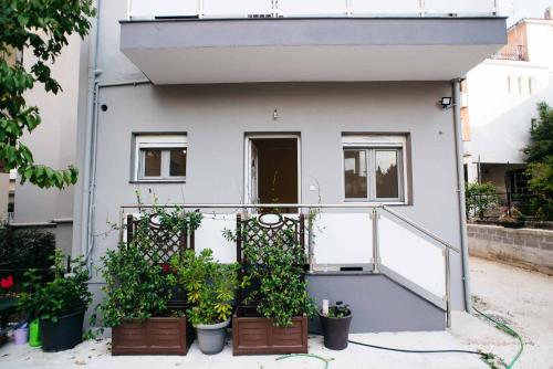 Ioannina City Relax Apartment في يوانينا: منزل فيه نباتات في قدور على الواجهه
