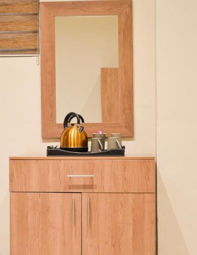 a mirror on top of a wooden dresser at Millennium hotel in Johannesburg