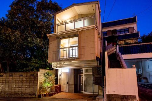 a tall house with lights in the window at Oyado Urushi / Vacation STAY 50682 in Nagasaki
