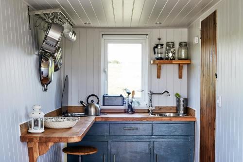 a kitchen with a counter and a sink and a window at Extraordinary Huts Ltd in Rye