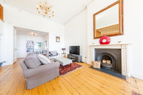 a living room with a couch and a fireplace at Elegant Period Clifton Balcony Apt - Simplycheckin in Bristol