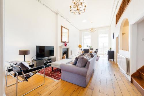 a living room with a couch and a tv at Elegant Period Clifton Balcony Apt - Simplycheckin in Bristol
