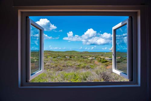 an open window with a view of a field at FONTEINTop in Willemstad